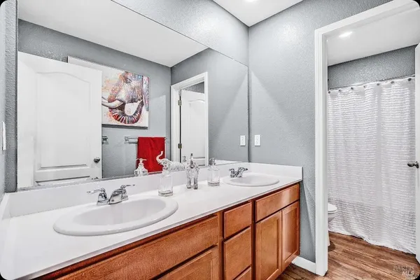 a bathroom with double vanity sinks a mirror and a shower
