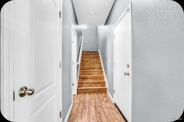 a view of a hallway with wooden floor and staircase