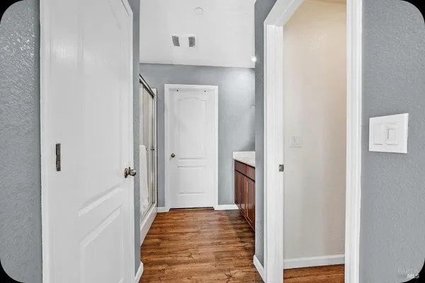 a view of a hallway with wooden floor and staircase
