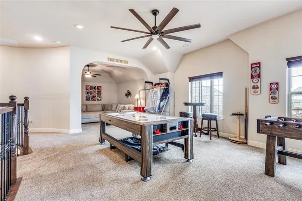 a bedroom with a bed couch and a ceiling fan