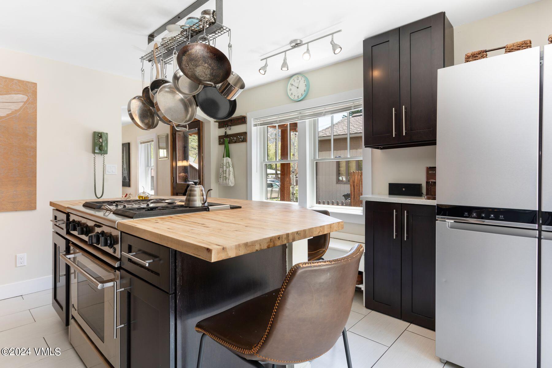 245 Pine Street Minturn, CO 81645 - Photo 11 of 44 a kitchen with stainless steel appliances granite countertop a stove a refrigerator and a sink with wooden floor