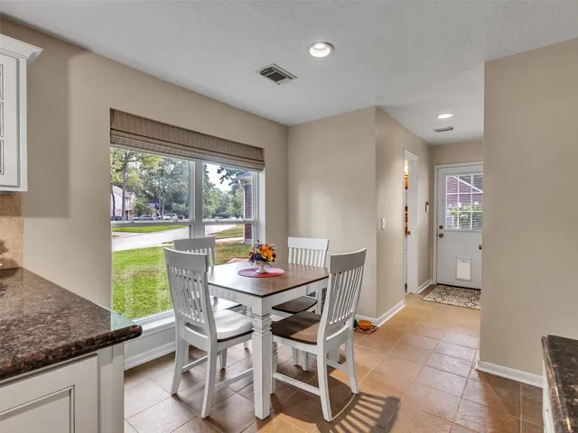 a dining room with furniture and a large window