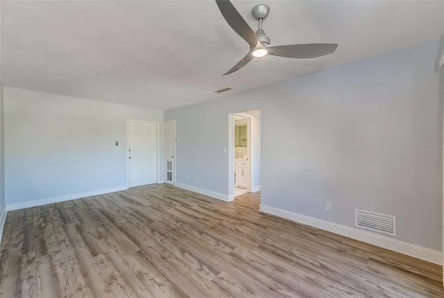a view of empty room with wooden floor