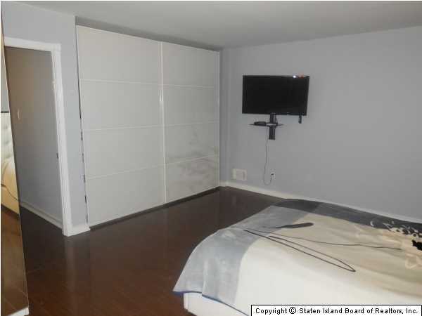 1640 Forest Hill Road Staten Island, NY 10314 - Photo 12 of 20 a bedroom with a bed and a flat screen tv