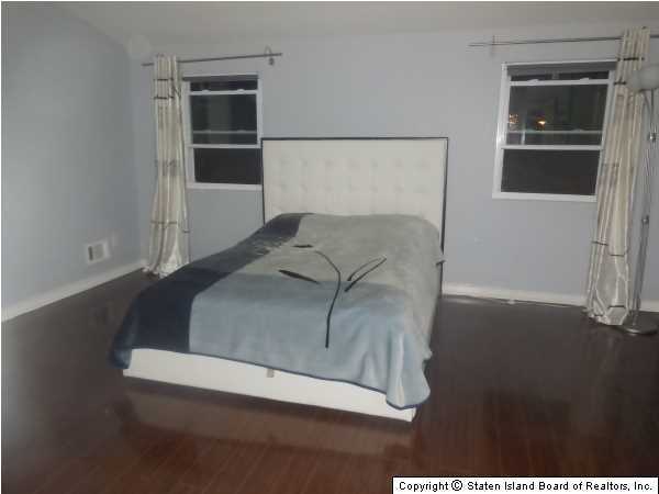 1640 Forest Hill Road Staten Island, NY 10314 - Photo 13 of 20 a bedroom with a bed and a night stand