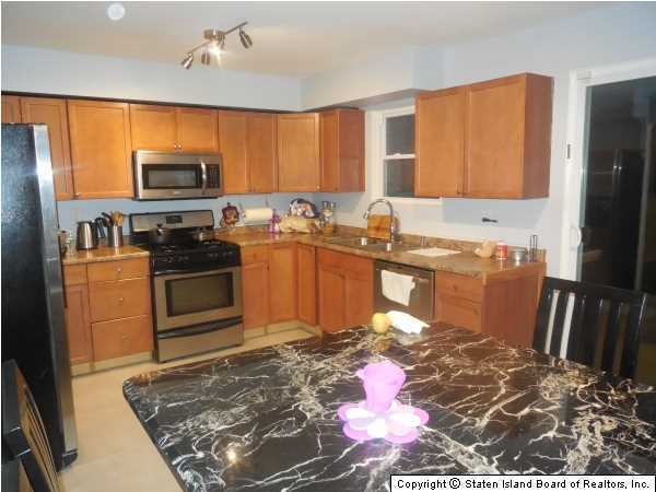 1640 Forest Hill Road Staten Island, NY 10314 - Photo 2 of 20 a kitchen with a stove a sink and a refrigerator