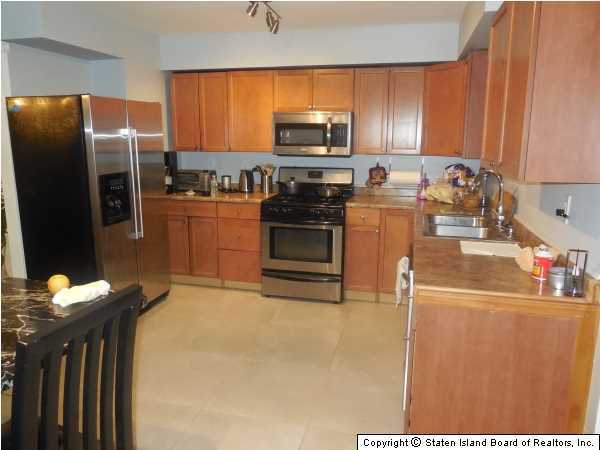 1640 Forest Hill Road Staten Island, NY 10314 - Photo 3 of 20 a kitchen with a refrigerator stove and microwave