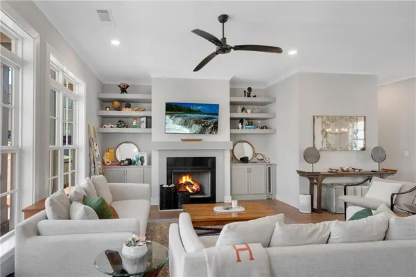 a kitchen with stainless steel appliances a refrigerator a stove a sink a dining table and chairs with wooden floor