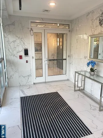a view of a hallway with wooden floor and windows