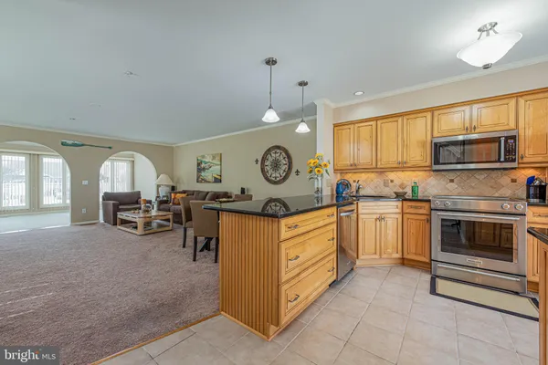 a kitchen with granite countertop a refrigerator and a stove top oven
