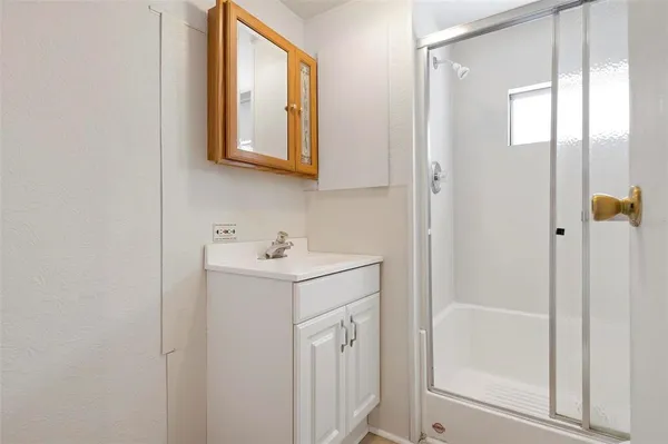 a bathroom with a shower sink and mirror