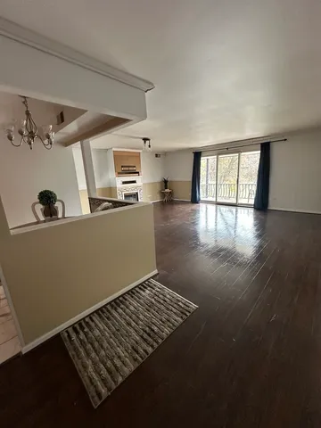 a view of a livingroom with wooden floor and a window