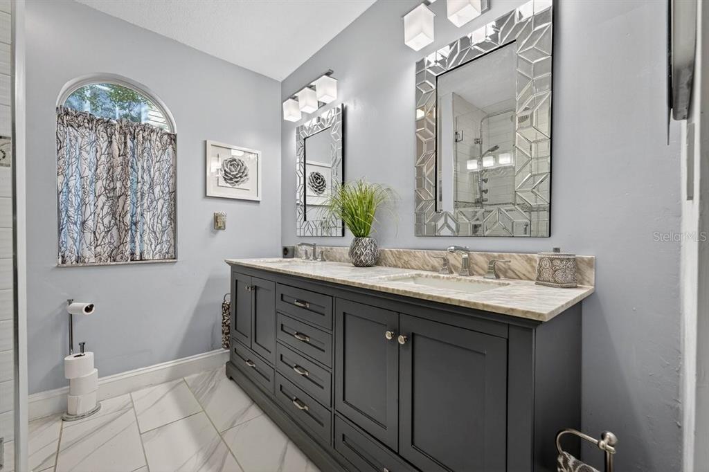 4758 South Peninsula Drive Ponce Inlet, FL 32127 - Photo 22 of 53 a bathroom with a double vanity sink and a mirror