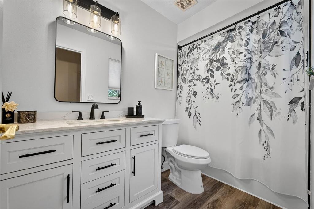 4758 South Peninsula Drive Ponce Inlet, FL 32127 - Photo 34 of 53 a bathroom with a granite countertop sink a toilet and a mirror