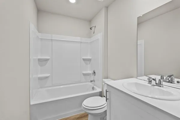 a bathroom with a granite countertop sink a toilet and shower