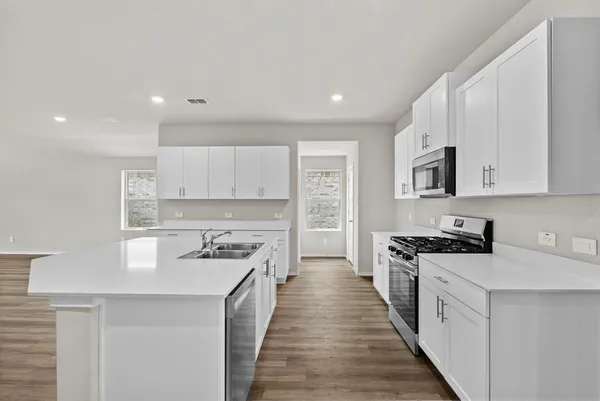 a kitchen with stainless steel appliances a stove sink microwave and cabinets