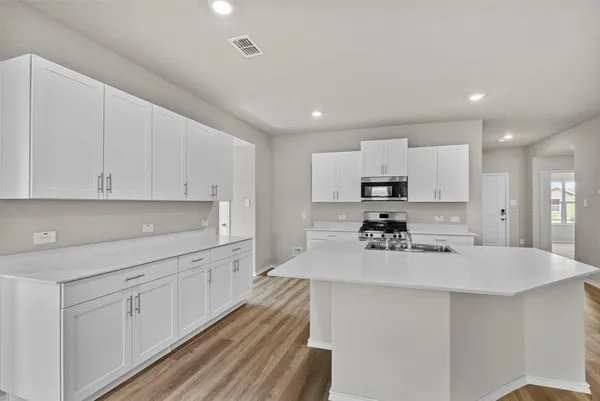 a kitchen with white cabinets and stainless steel appliances
