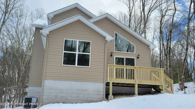 a view of house with a yard and wooden fence