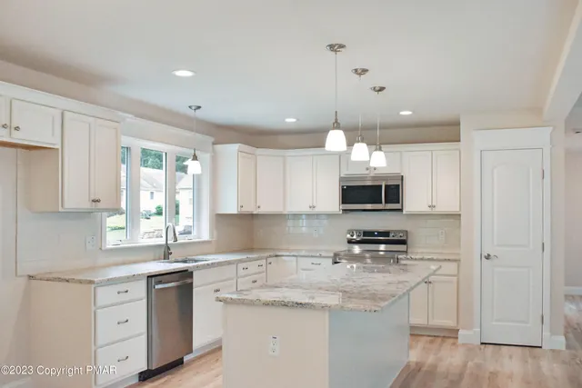 a kitchen with a white stove top oven sink and cabinets