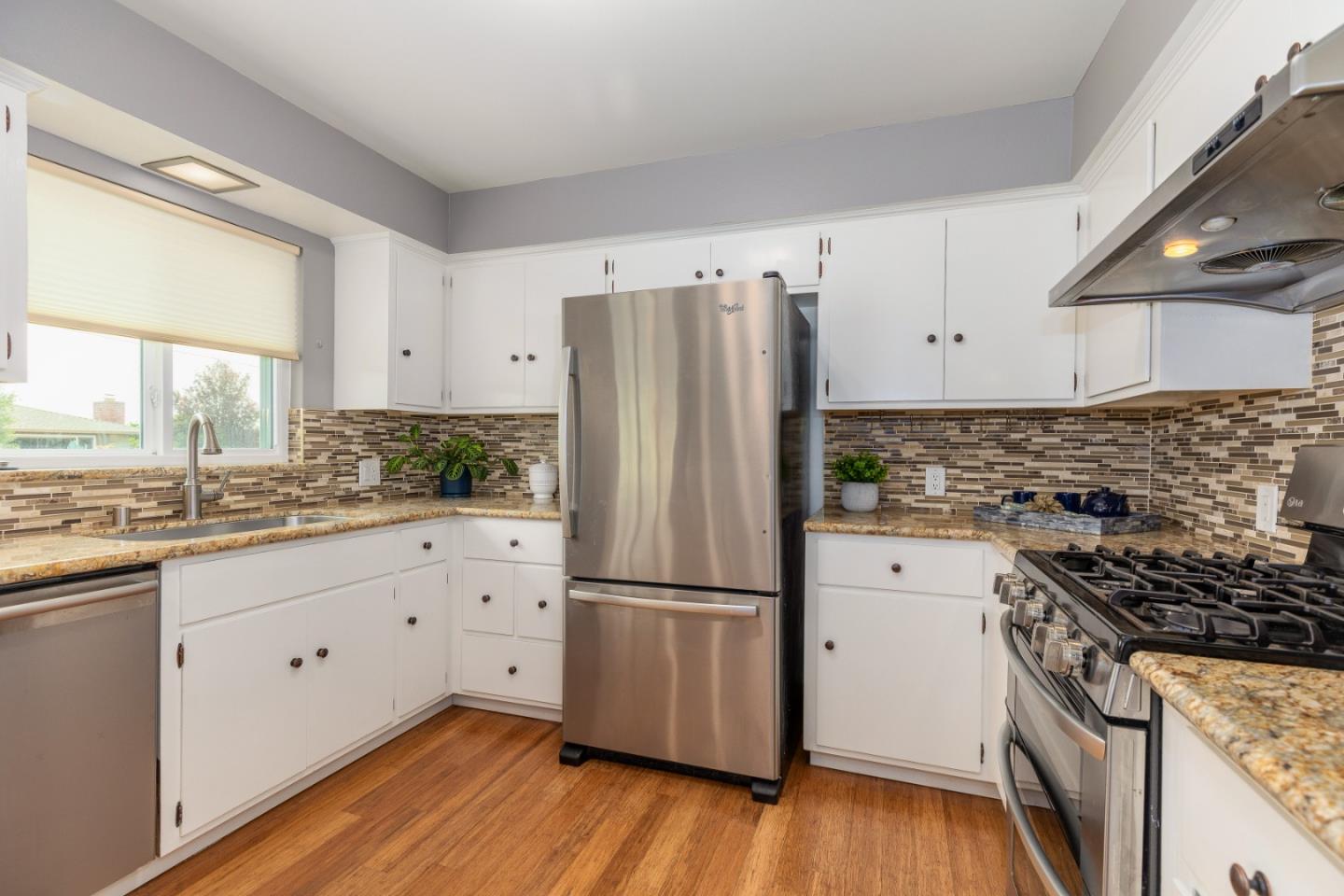 2479 Longview Drive San Leandro, CA 94577 - Photo 14 of 57 a kitchen with granite countertop stainless steel appliances a refrigerator sink and wooden floor