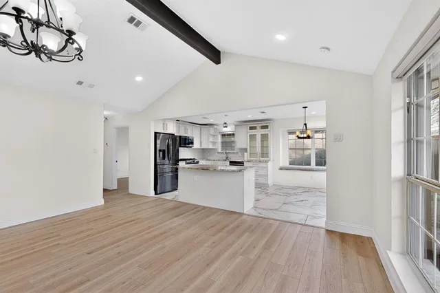 a kitchen with granite countertop a refrigerator stove top oven and sink