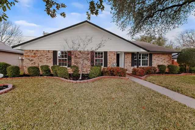 a view of a house with a yard and potted plants