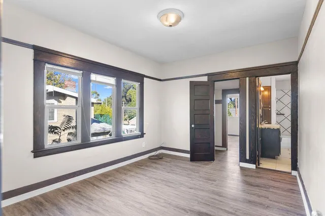 a view of an empty room with wooden floor