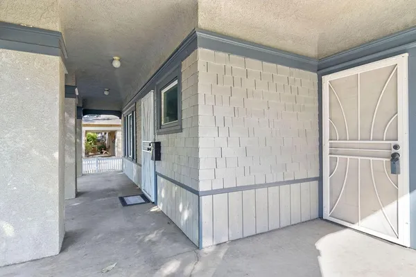 a view of a hallway with wooden floor and a livingroom
