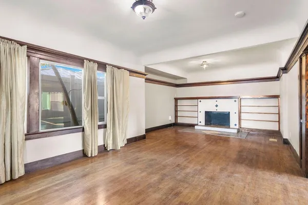 an empty room with fireplace and windows