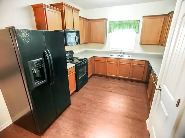 a kitchen with granite countertop cabinets stainless steel appliances a sink and a window