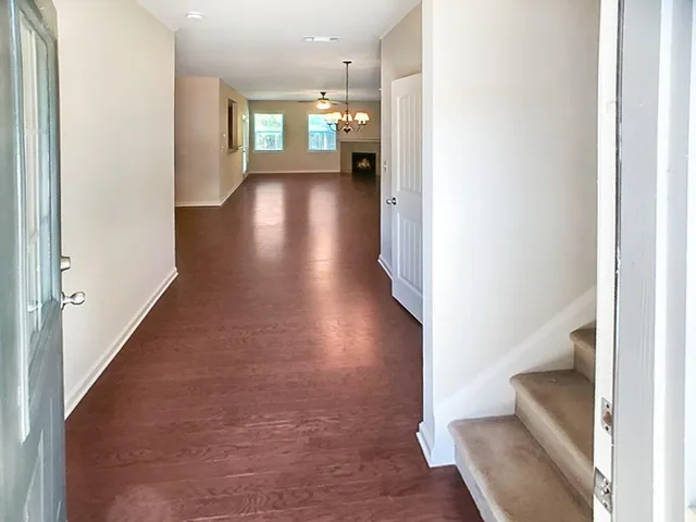 a view of a hallway with wooden floor