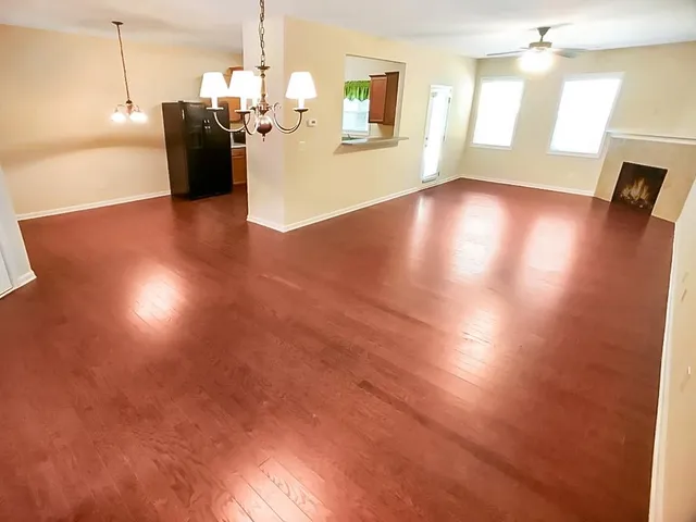 a view of an empty room with a fireplace and a window
