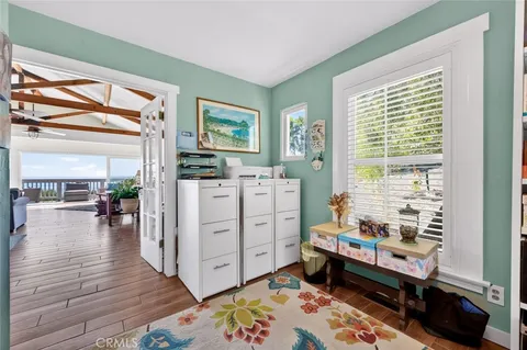 a view of kitchen with stainless steel appliances wooden floor and chair
