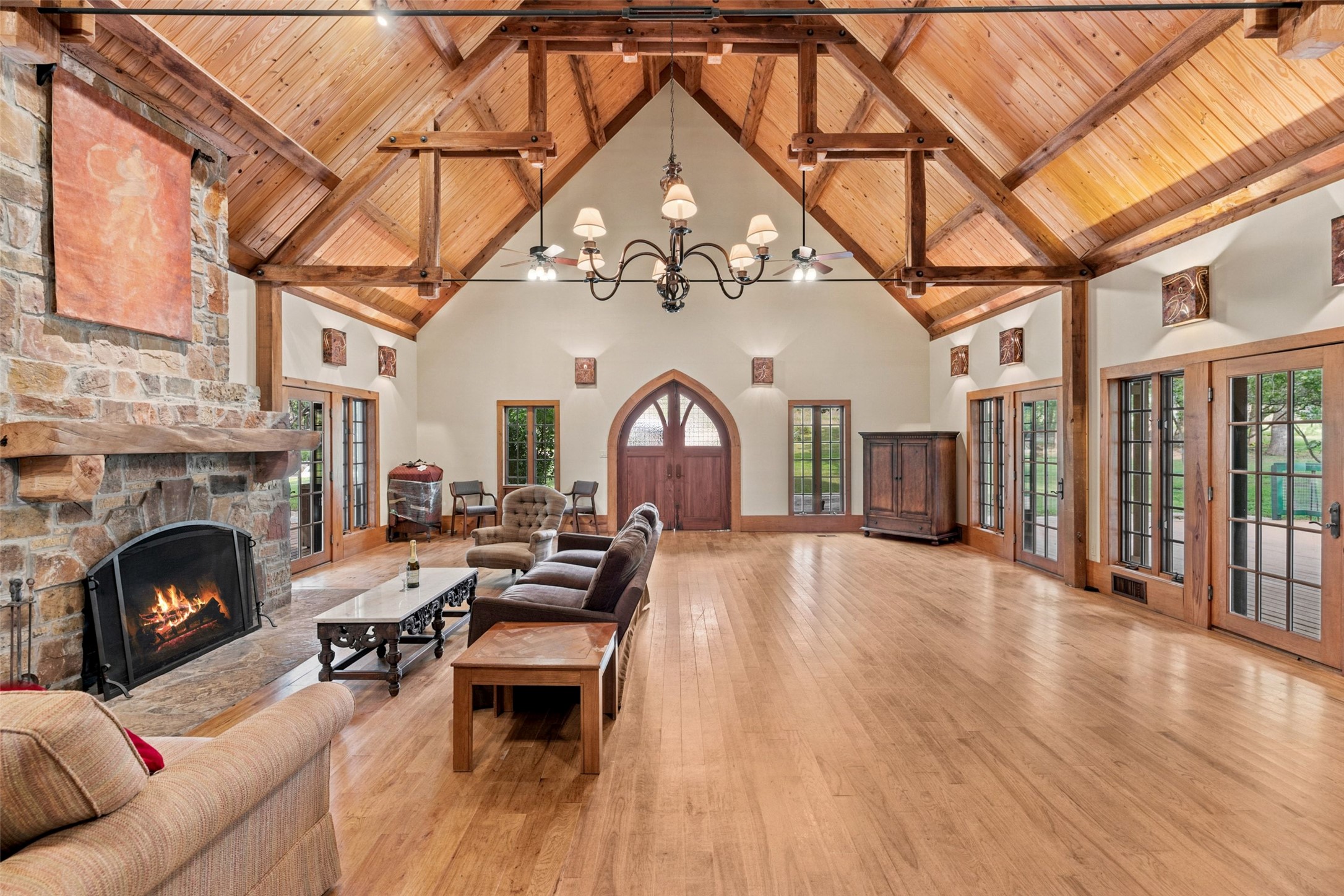 505 Red Corral Ranch Road Wimberley, TX 78676 - Photo 20 of 40 A spacious living area boasts exposed wood beam ceilings, a grand fireplace, and polished hardwood floors.