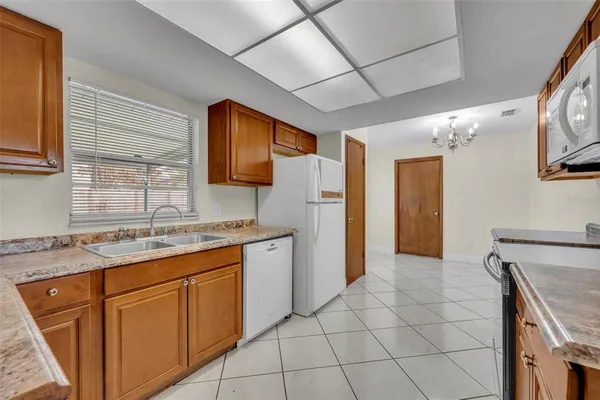 a kitchen with granite countertop a refrigerator and a sink