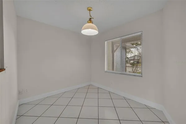 an empty room with wooden floor ceiling fan and windows