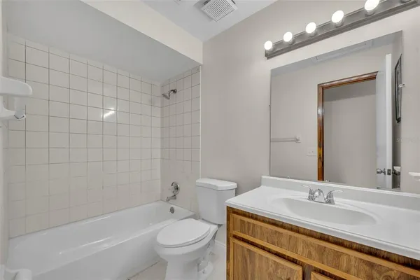 a view of an empty room with closet and a bathroom