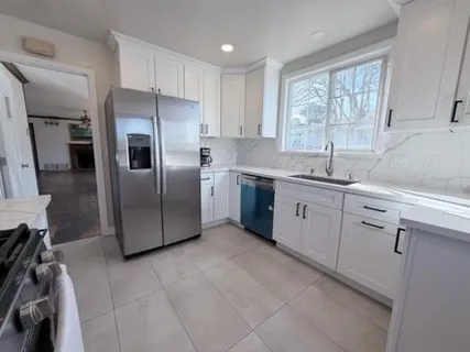 a kitchen with a sink window and refrigerator