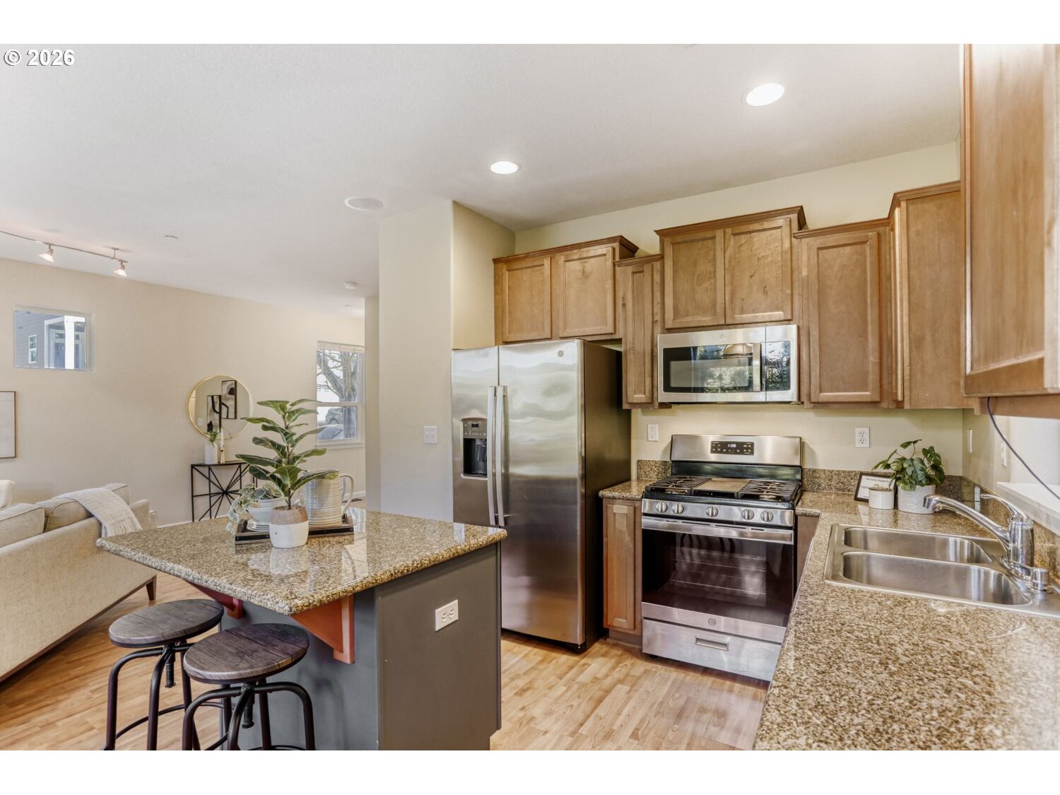 12675 Southwest 158th Terrace Beaverton, OR 97007 - Photo 7 of 26 a kitchen with stainless steel appliances a sink a stove a refrigerator cabinets and dining table
