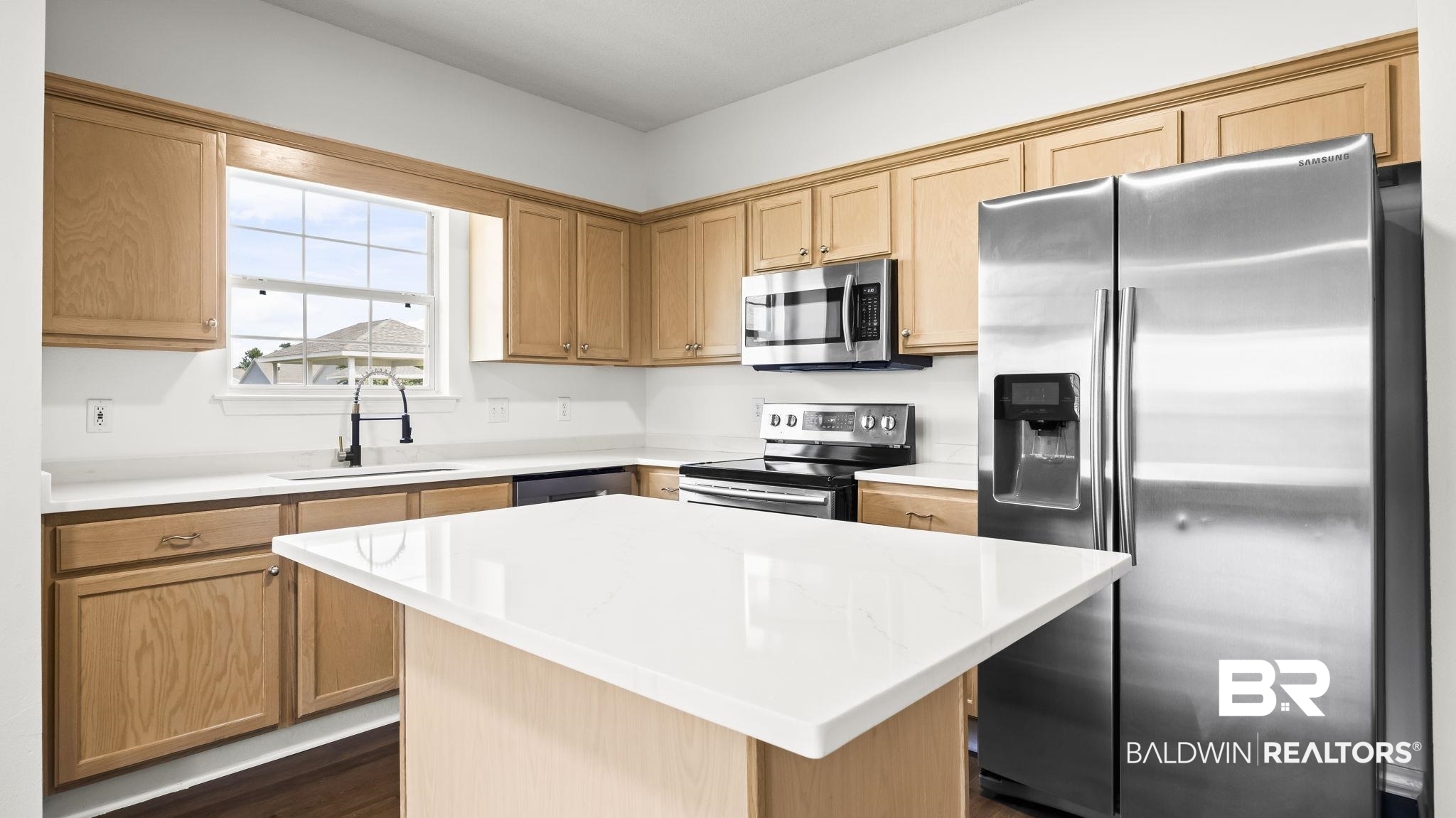 2651 South Juniper Street, Unit 705 Foley, AL 36535 - Photo 7 of 37 Kitchen featuring light wood cabinetry, a central island with a white countertop, stainless steel appliances, a double-basin sink with a gooseneck faucet, and white countertops