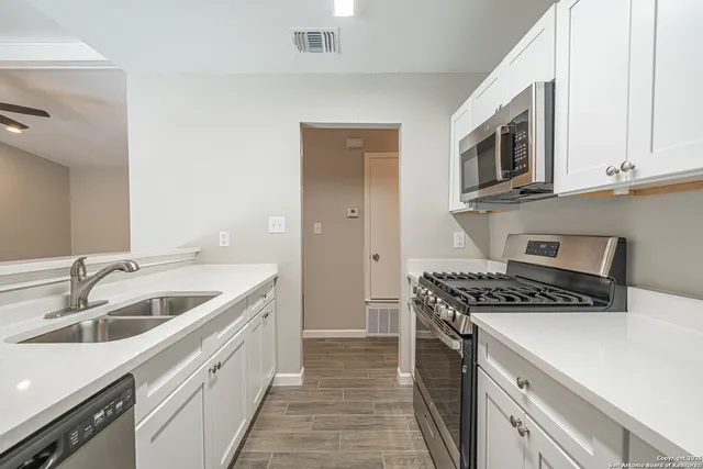 a kitchen with stainless steel appliances granite countertop a sink and a stove