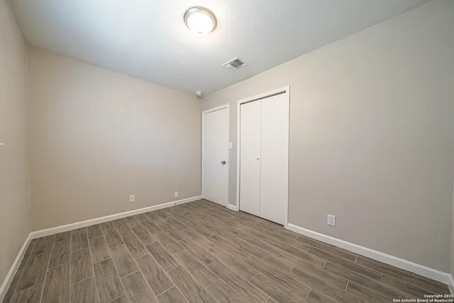 a view of an empty room with wooden floor