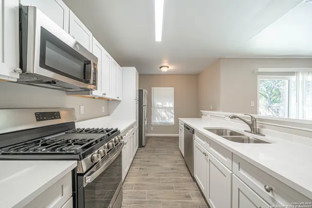 a kitchen with stainless steel appliances granite countertop a sink and a stove