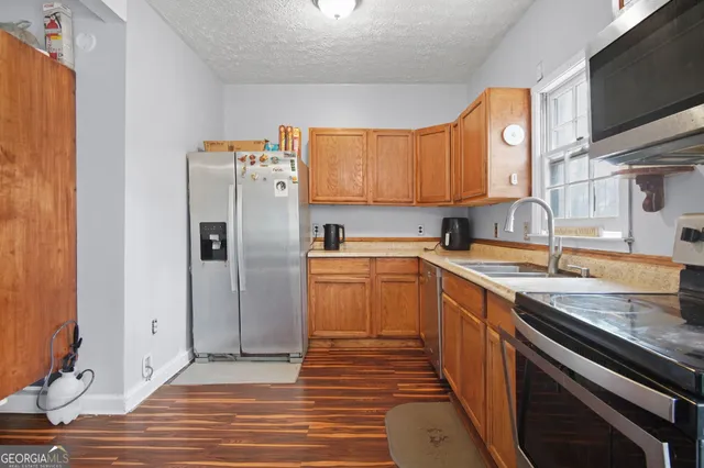 a kitchen with granite countertop a refrigerator and a sink