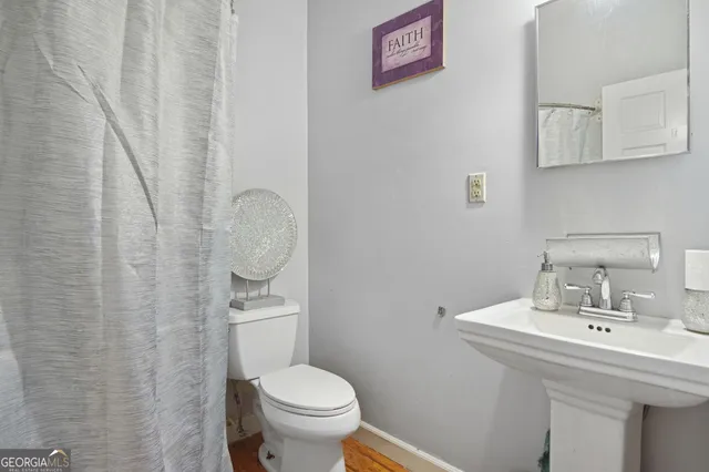 a bathroom with a sink a toilet and a mirror
