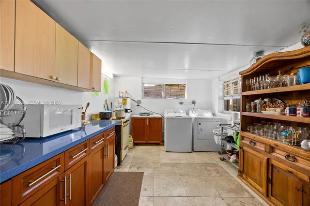a kitchen with a dining table chairs and a window