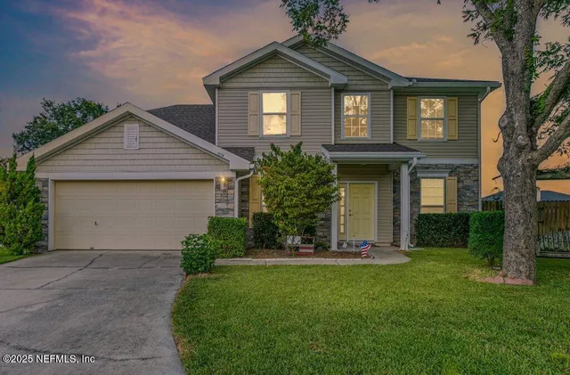 a front view of a house with a yard and trees