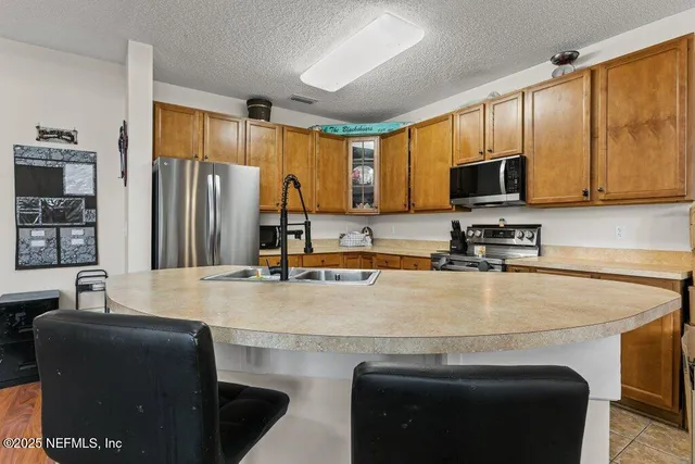 a kitchen with stainless steel appliances granite countertop a sink a stove and a refrigerator