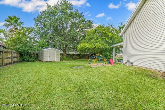 a view of a backyard with a garden and entertaining space