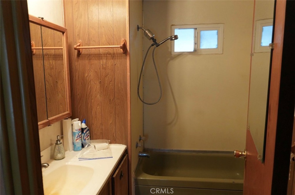 15940 Stoddard Wells Road, Unit 50HWY Victorville, CA 92395 - Photo 11 of 15 a bathroom with a granite countertop sink a mirror and shower